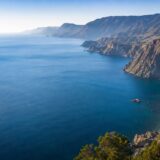 Глубокая синяя акватория Чёрного моря у гористого берега