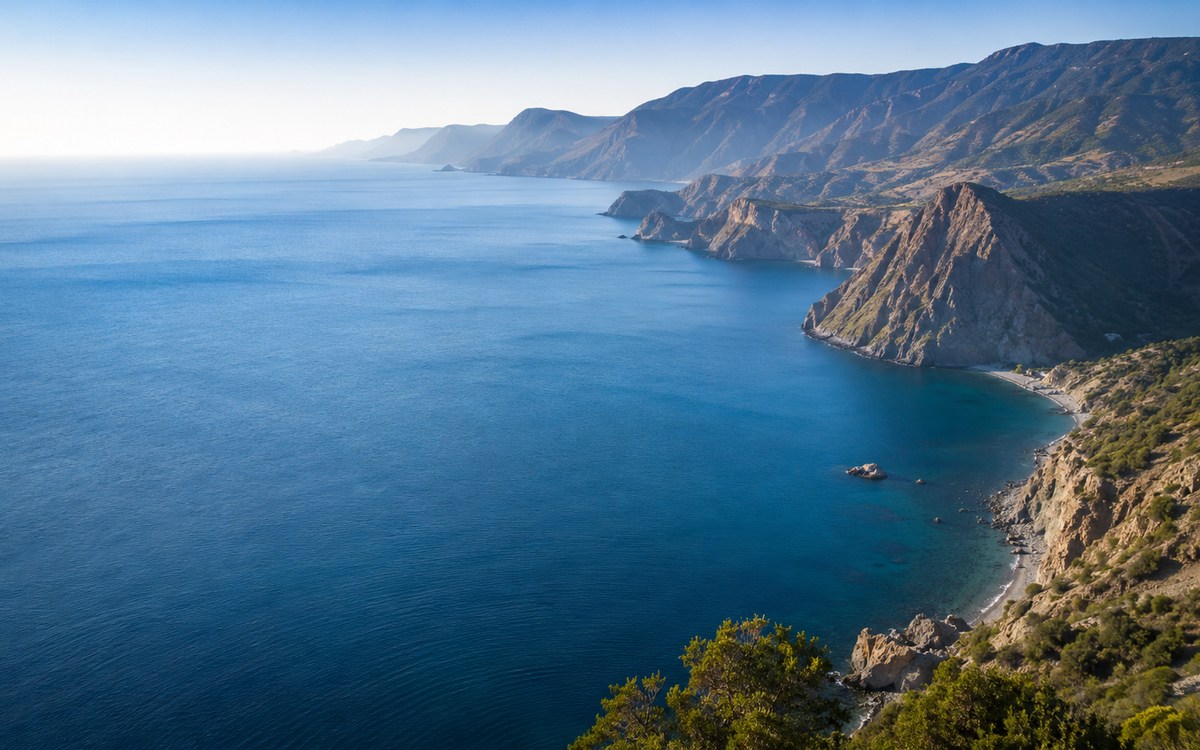 Глубокая синяя акватория Чёрного моря у гористого берега